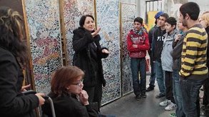 Eine Gehörlosendolmetscherin führt eine Gruppe durch eine Ausstellung.